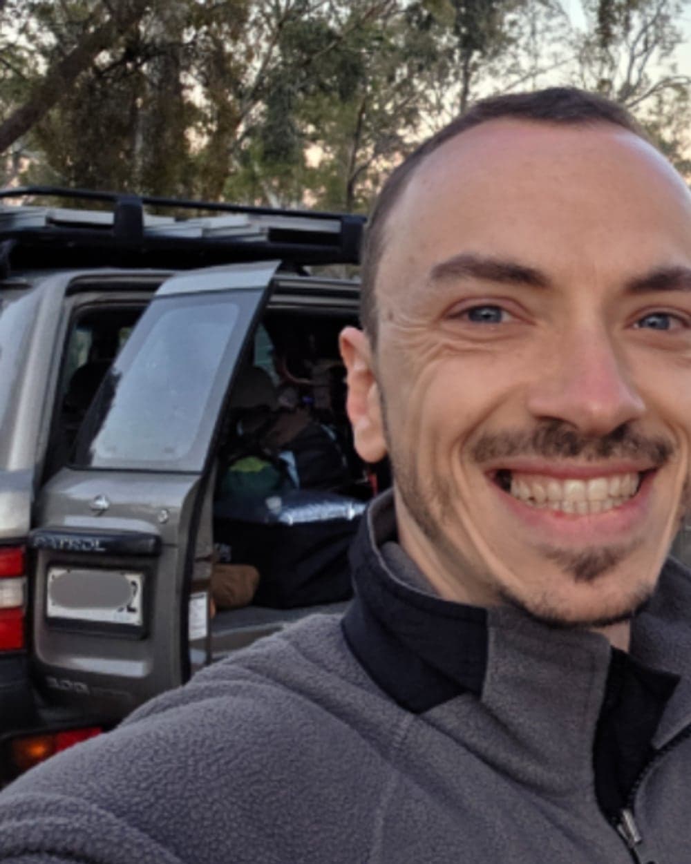 Chris Lourenco beside his Nissan Patrol at a bush campsite, the rear loaded with touring gear.